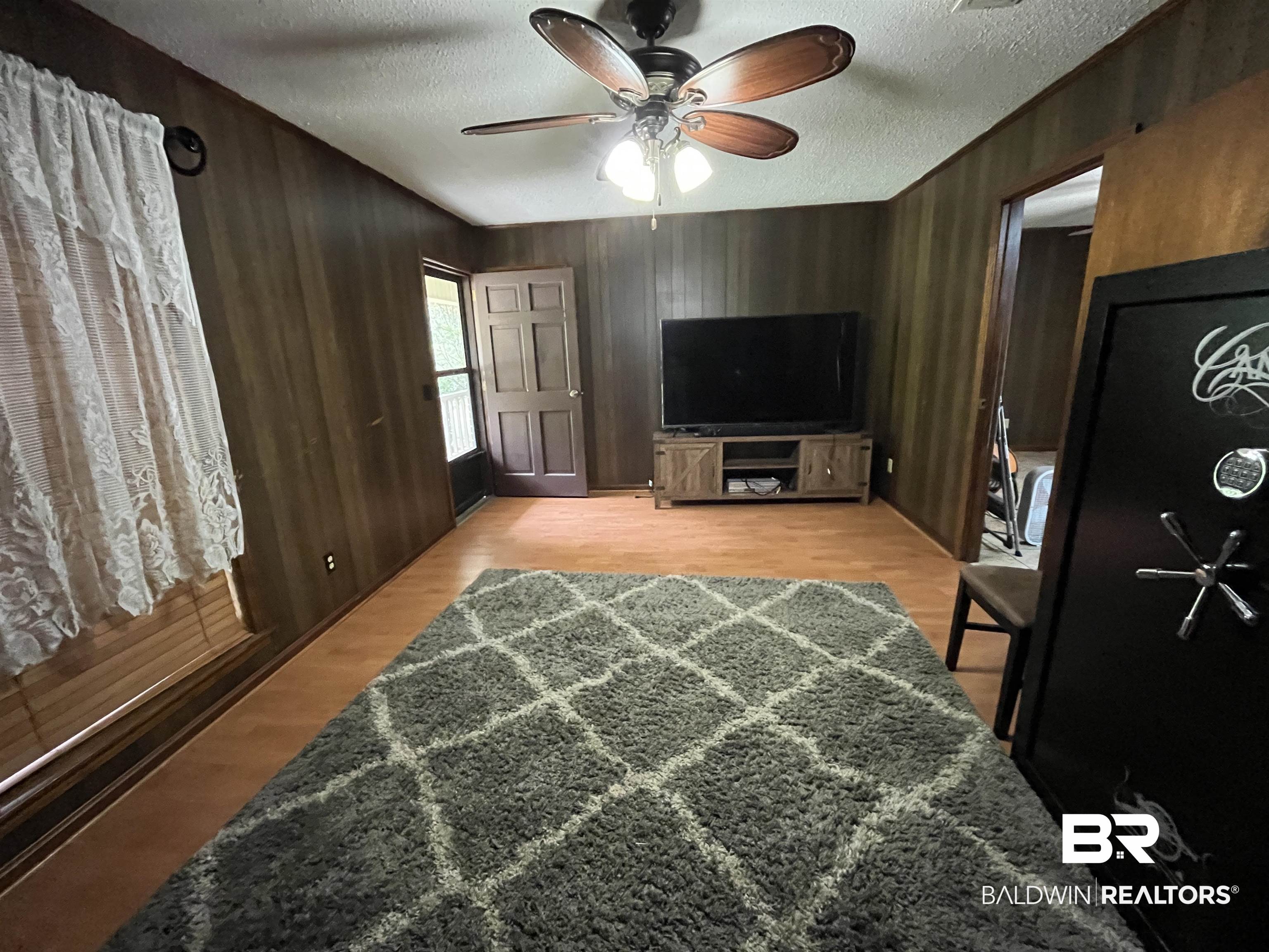 1905 Rockaway Creek Road Atmore, AL 36502 - Photo 8 of 23 Interior space featuring wood-finish flooring, wood paneling, and a ceiling fan with integrated lighting