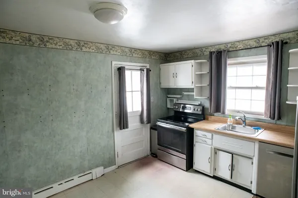 a kitchen with granite countertop a sink stainless steel appliances and cabinets