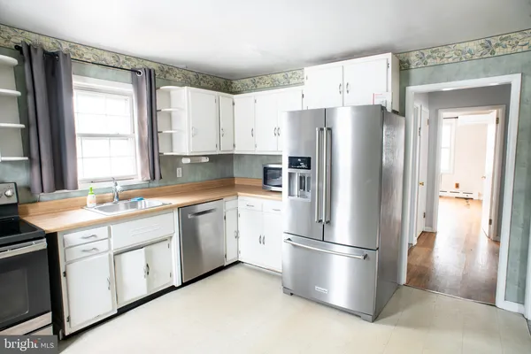 a kitchen with stainless steel appliances a refrigerator sink and cabinets