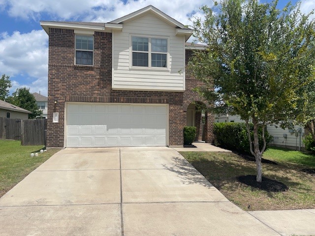 A classic brick and siding two-story residence with an attached garage and inviting entry.