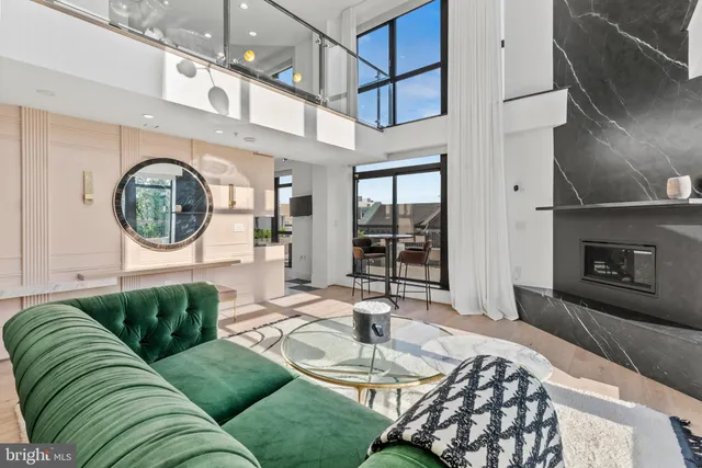 a living room with furniture a fireplace and a large window