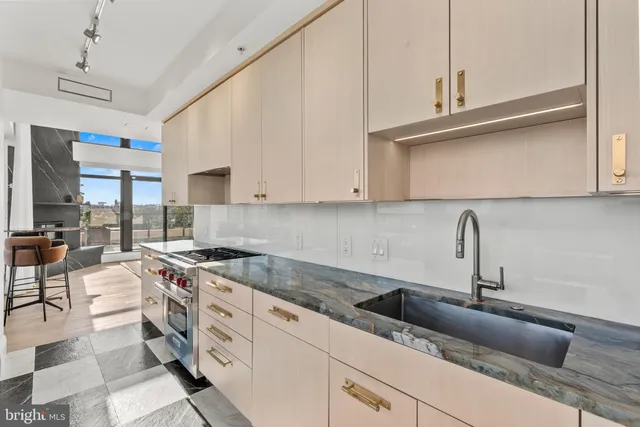 a kitchen with stainless steel appliances granite countertop a sink stove and cabinets