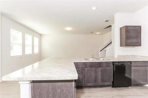 a kitchen with a sink a counter top space and windows
