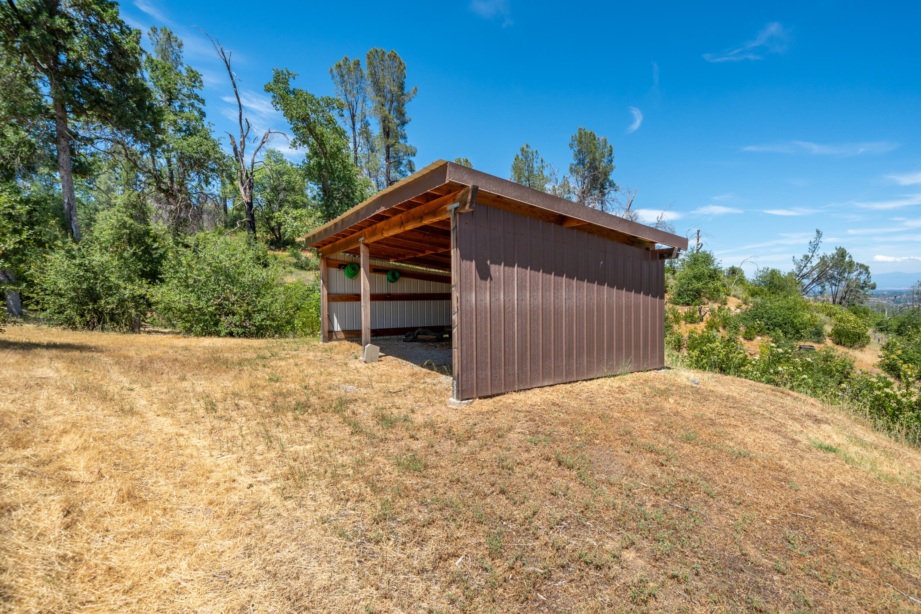 15809 Old Stage Coach Road Redding, CA 96001 - Photo 21 of 44 a view of wooden house with a yard and large trees
