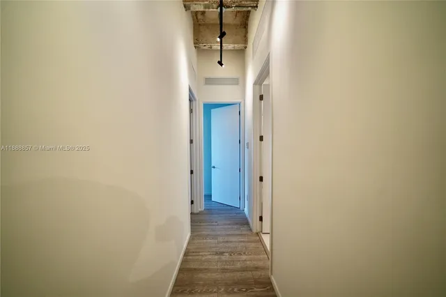 a view of a hallway with wooden floor