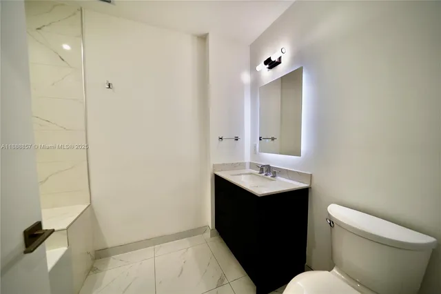 a bathroom with a sink and mirror with toilet