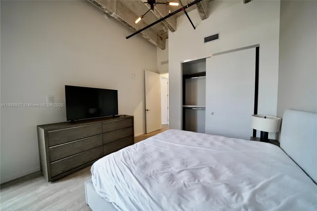 a bedroom with a bed and a flat screen tv