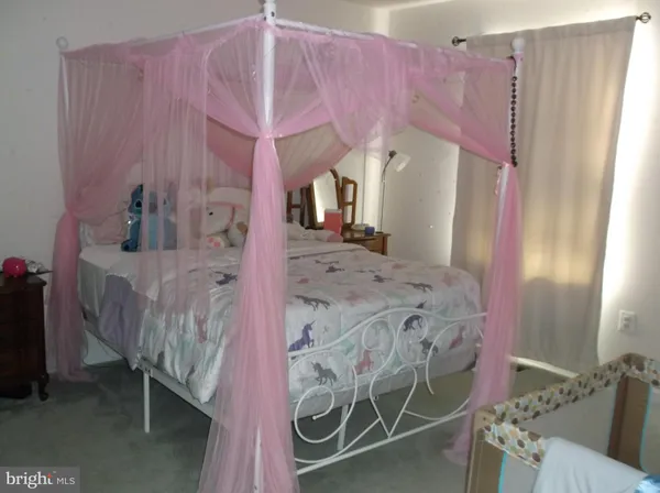 a spacious bedroom with a bed and a dresser