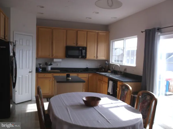 a kitchen with granite countertop a sink chairs and window