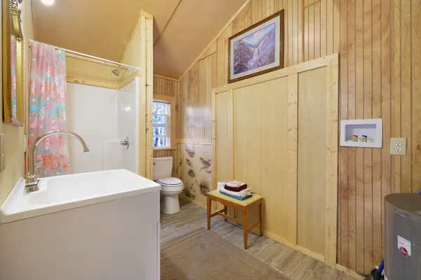 a bathroom with a sink a toilet and shower