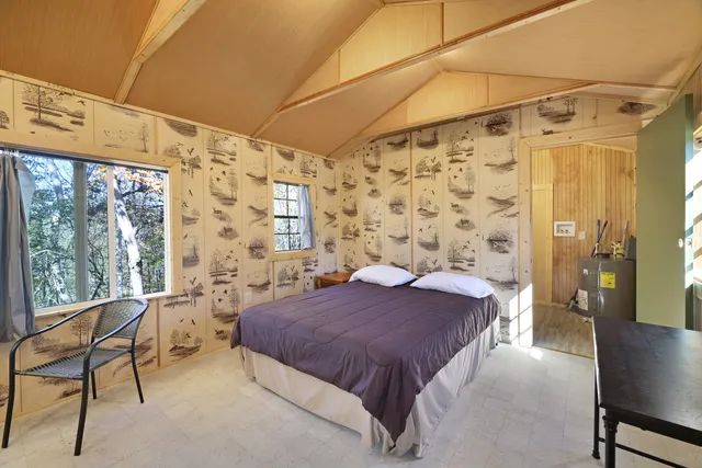 a spacious bedroom with a bed and a chair