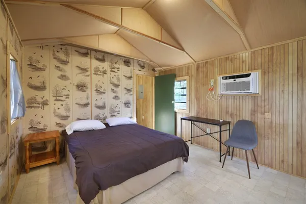 a room with furniture a flat screen tv and refrigerator
