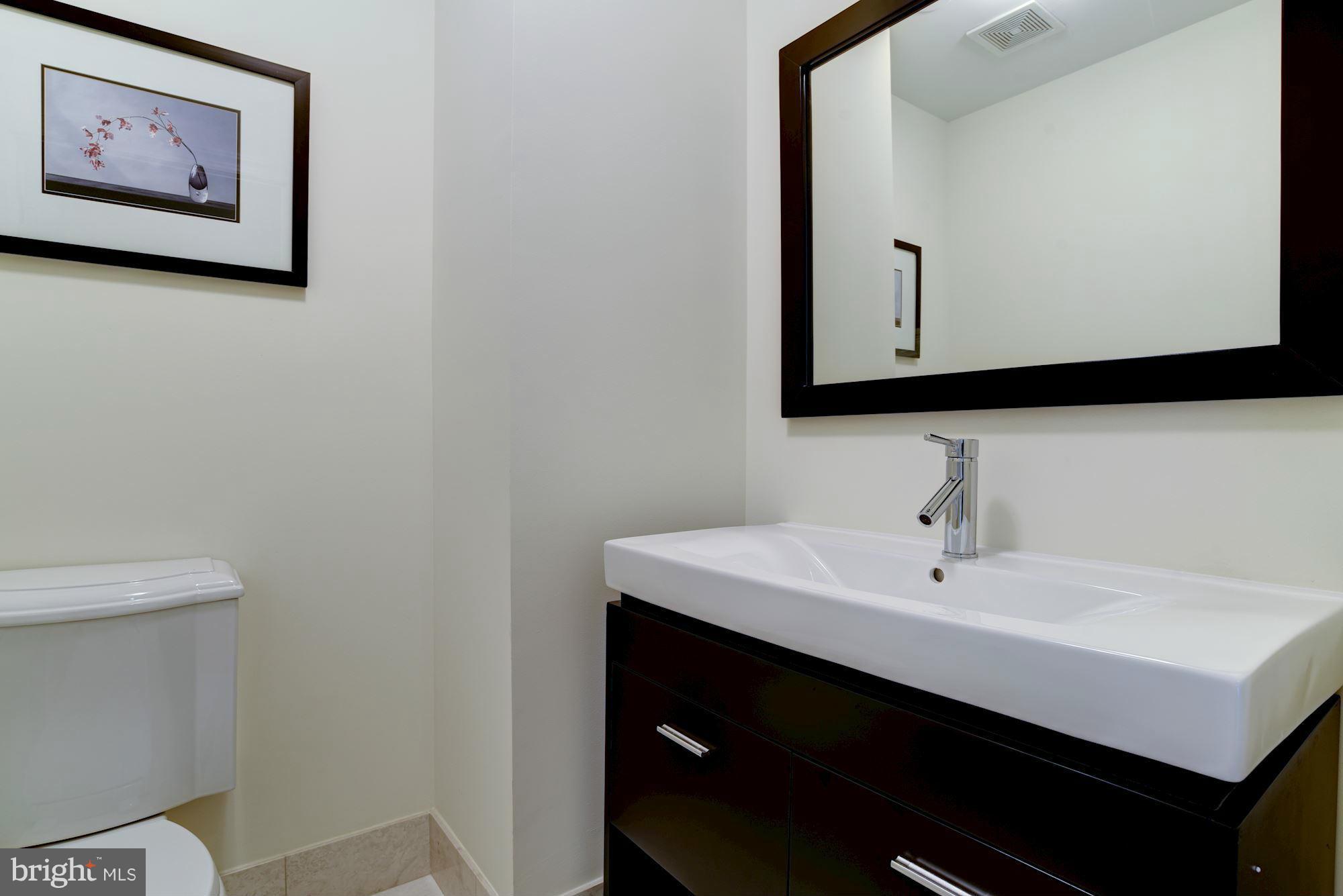 2425 L Street Northwest, Unit 340 Washington, DC 20037 - Photo 13 of 30 a bathroom with a sink and a mirror