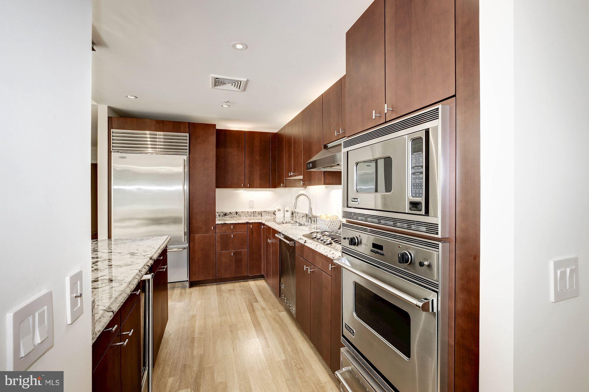 2425 L Street Northwest, Unit 340 Washington, DC 20037 - Photo 9 of 30 a kitchen with stainless steel appliances granite countertop a stove and a refrigerator
