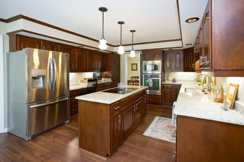 a kitchen with kitchen island a counter top space a sink appliances and cabinets