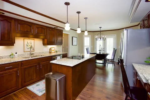 a kitchen with stainless steel appliances granite countertop wooden floors sink stove and cabinets