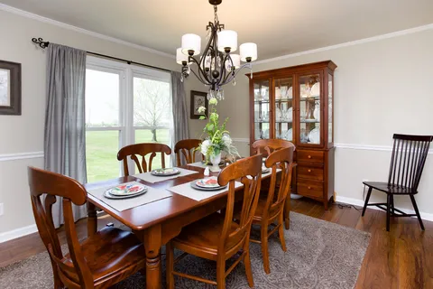 a view of a dining room with furniture wooden floor and chandelier