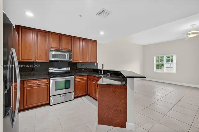 a kitchen with stainless steel appliances granite countertop a stove a sink and a refrigerator