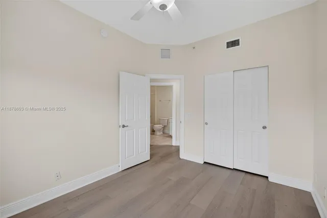 a view of a livingroom with a chandelier fan and windows