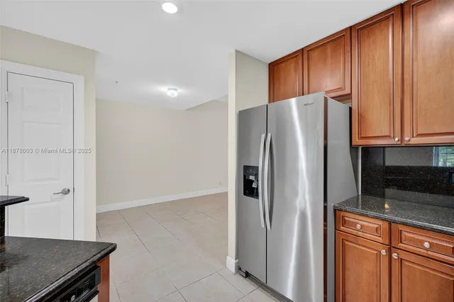 a kitchen with stainless steel appliances granite countertop a refrigerator and a sink