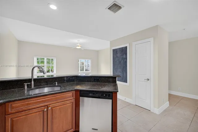 a kitchen with granite countertop a sink and cabinets