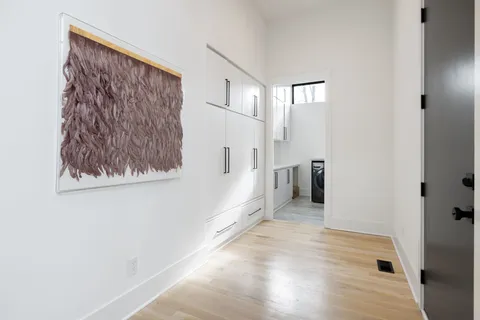 a living room with furniture a clock on wall and a large window