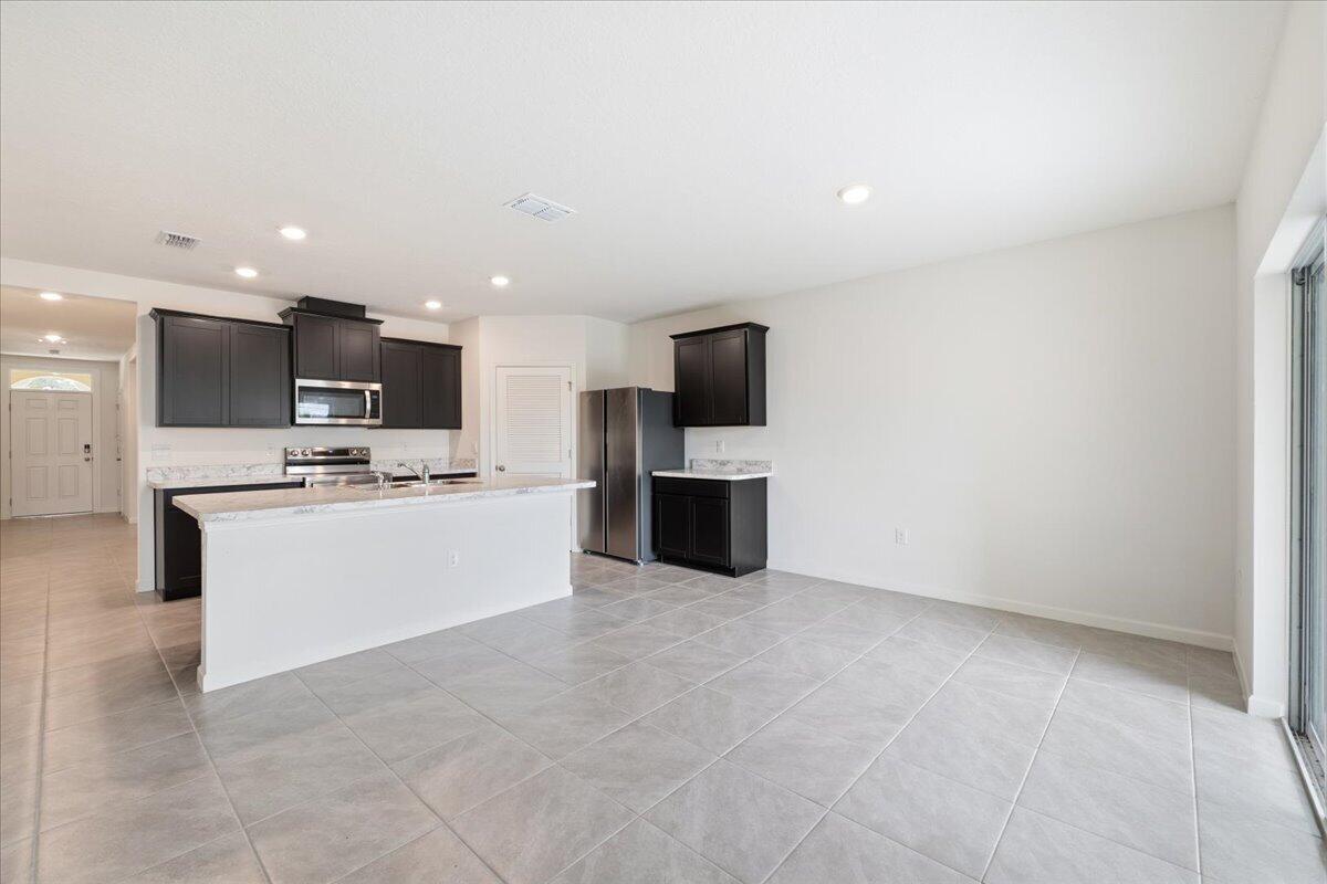 1072 Roseland Road Sebastian, FL 32958 - Photo 5 of 47 a view of kitchen with kitchen island granite countertop cabinets and flat screen tv