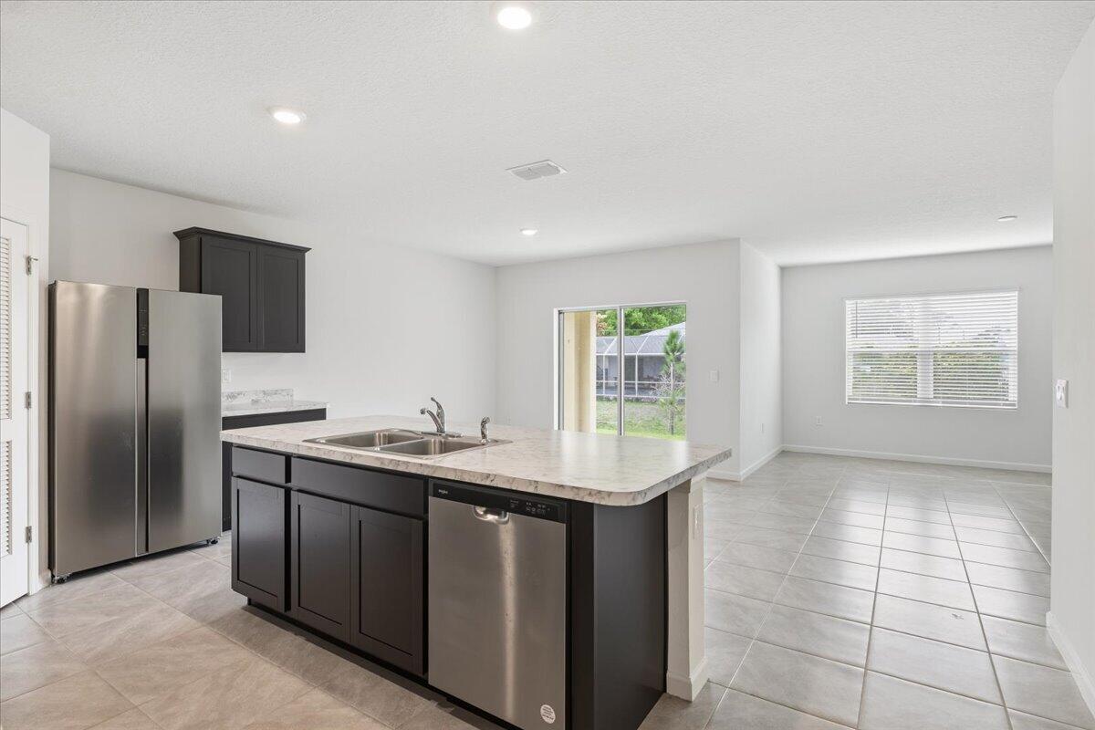 1072 Roseland Road Sebastian, FL 32958 - Photo 6 of 47 a kitchen with stainless steel appliances granite countertop a sink and a refrigerator
