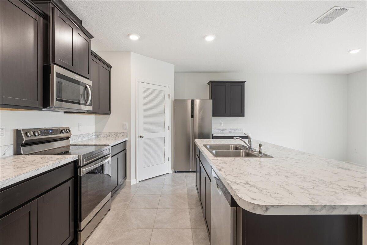 1072 Roseland Road Sebastian, FL 32958 - Photo 8 of 47 a kitchen with stainless steel appliances granite countertop a sink stove and refrigerator