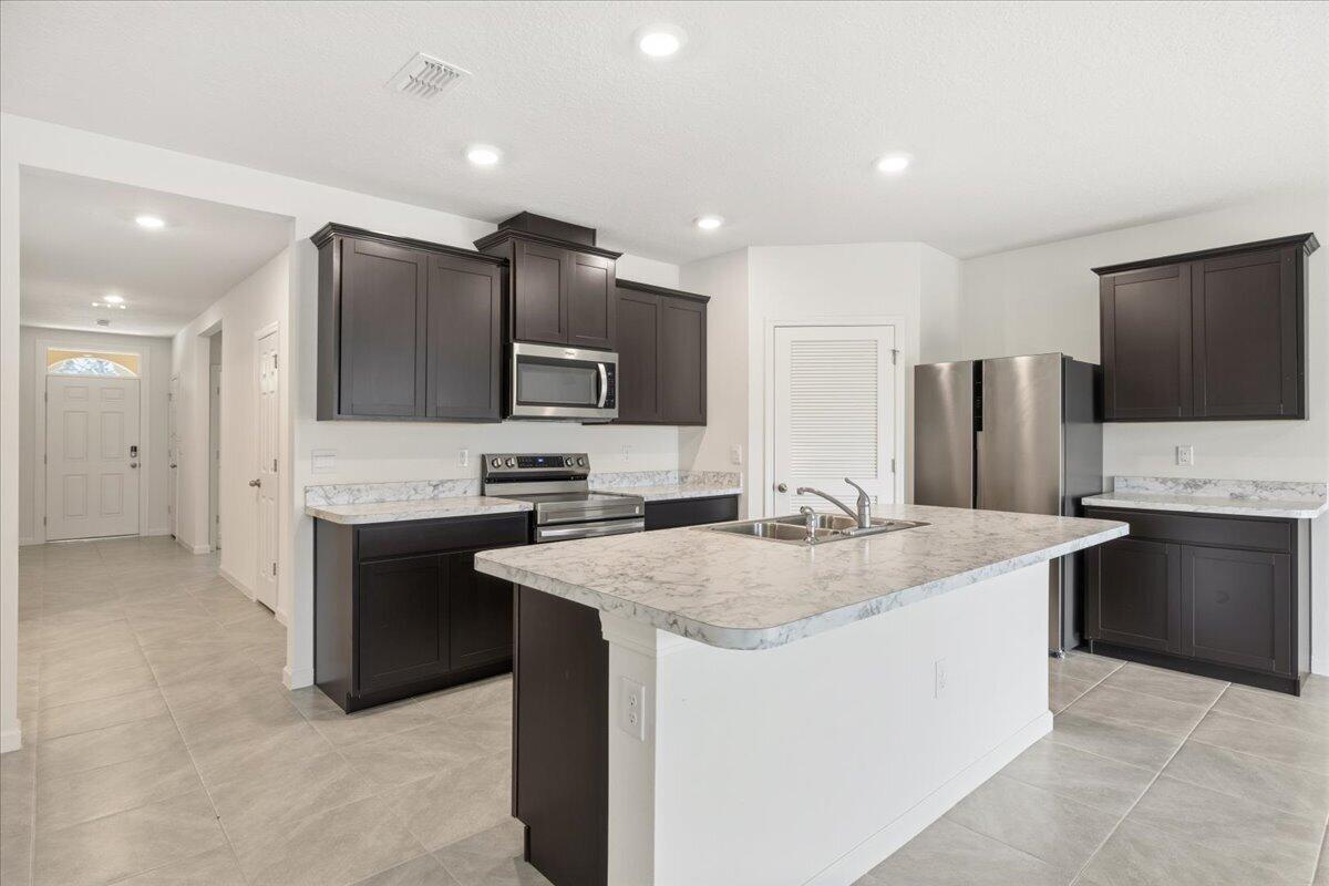 1072 Roseland Road Sebastian, FL 32958 - Photo 9 of 47 a kitchen with stainless steel appliances granite countertop a sink stove and refrigerator