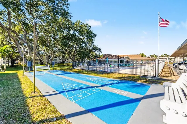 a view of swimming pool with lawn chairs under an umbrella