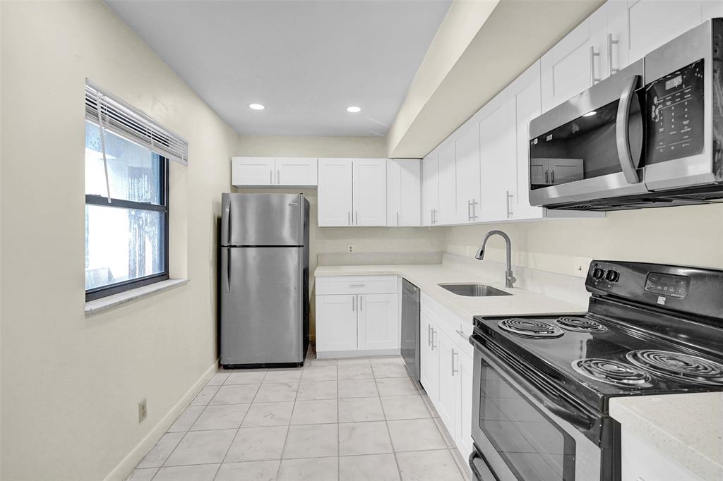 a kitchen with stainless steel appliances granite countertop a stove a refrigerator and a microwave