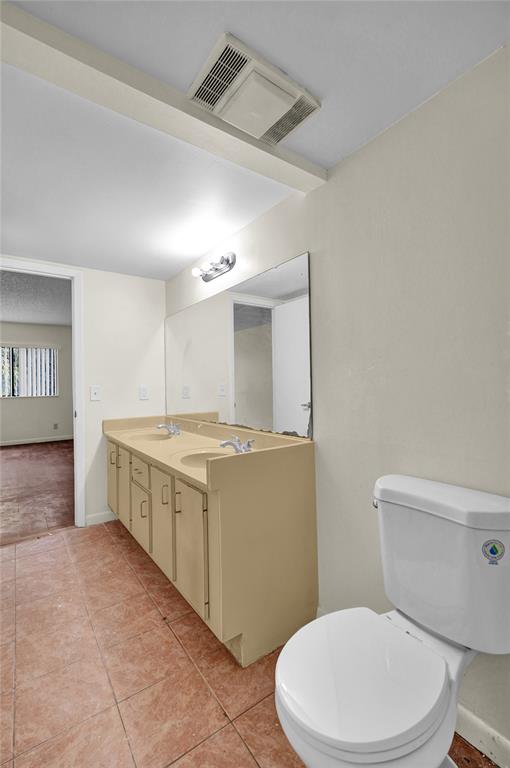 4218 Inverrary Boulevard, Unit 95B Lauderhill, FL 33319 - Photo 14 of 36 a bathroom with a granite countertop toilet sink and mirror