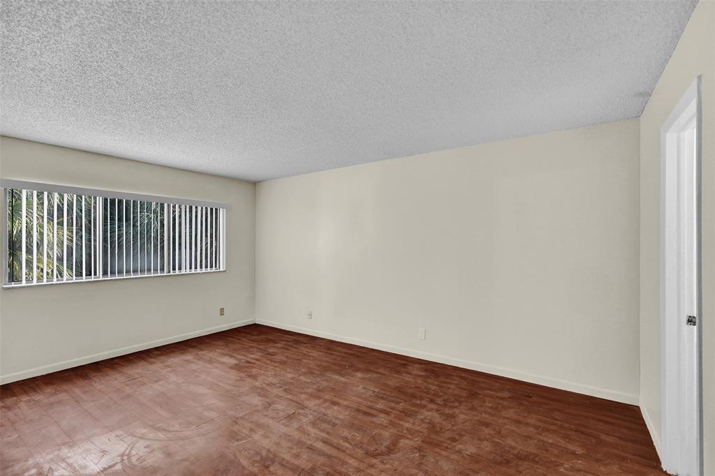 4218 Inverrary Boulevard, Unit 95B Lauderhill, FL 33319 - Photo 23 of 36 a view of an empty room with wooden floor and a window