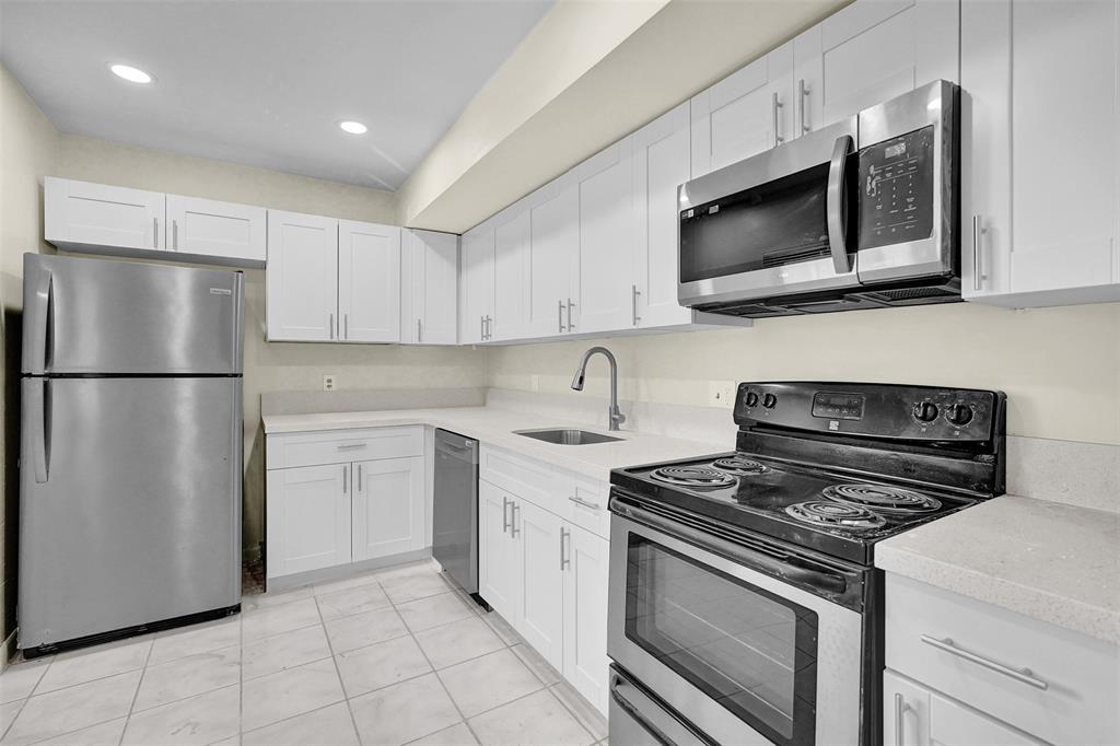 4218 Inverrary Boulevard, Unit 95B Lauderhill, FL 33319 - Photo 4 of 36 a kitchen with a stove microwave and refrigerator