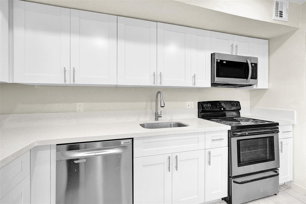 4218 Inverrary Boulevard, Unit 95B Lauderhill, FL 33319 - Photo 5 of 36 a kitchen with a sink stove and microwave