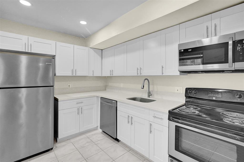 4218 Inverrary Boulevard, Unit 95B Lauderhill, FL 33319 - Photo 6 of 36 a kitchen with stainless steel appliances granite countertop a refrigerator sink and white cabinets