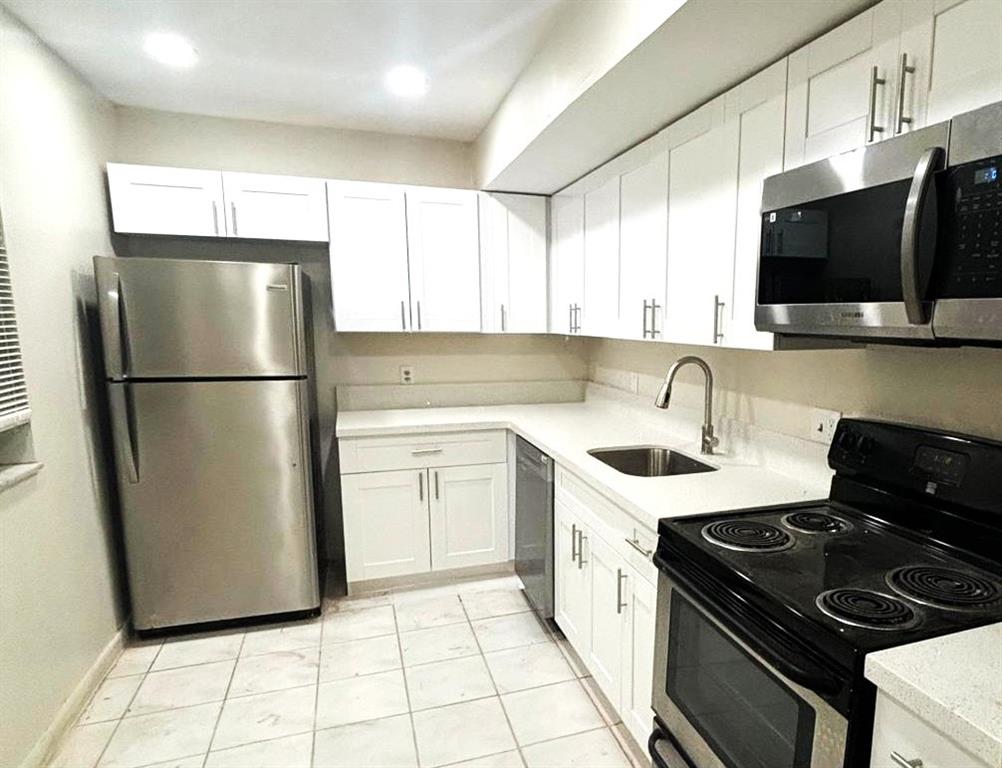 4218 Inverrary Boulevard, Unit 95B Lauderhill, FL 33319 - Photo 7 of 36 a kitchen with a sink stove and refrigerator