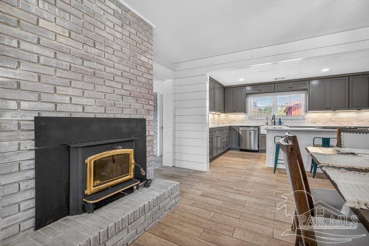 8940 Indian Ford Road Milton, FL 32570 - Photo 21 of 54 a living room with stainless steel appliances furniture a fireplace and a ceiling fan