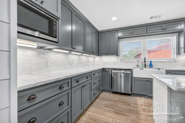a kitchen with stainless steel appliances granite countertop a sink stove and cabinets