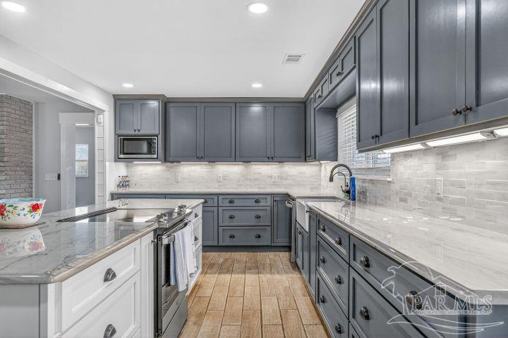 8940 Indian Ford Road Milton, FL 32570 - Photo 27 of 54 a kitchen with stainless steel appliances granite countertop a sink stove and cabinets