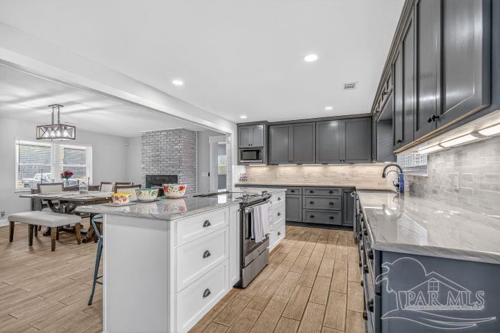 8940 Indian Ford Road Milton, FL 32570 - Photo 28 of 54 a kitchen with stainless steel appliances granite countertop a sink stove and refrigerator