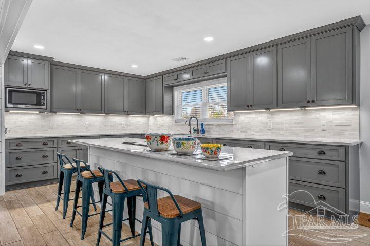 8940 Indian Ford Road Milton, FL 32570 - Photo 29 of 54 a kitchen with stainless steel appliances granite countertop a stove a sink dishwasher and a refrigerator with wooden cabinets