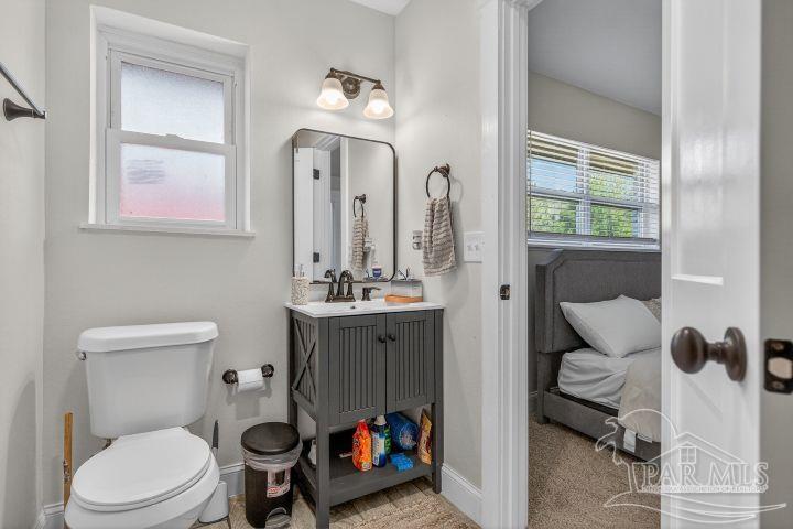8940 Indian Ford Road Milton, FL 32570 - Photo 42 of 54 a bathroom with a toilet a sink and mirror