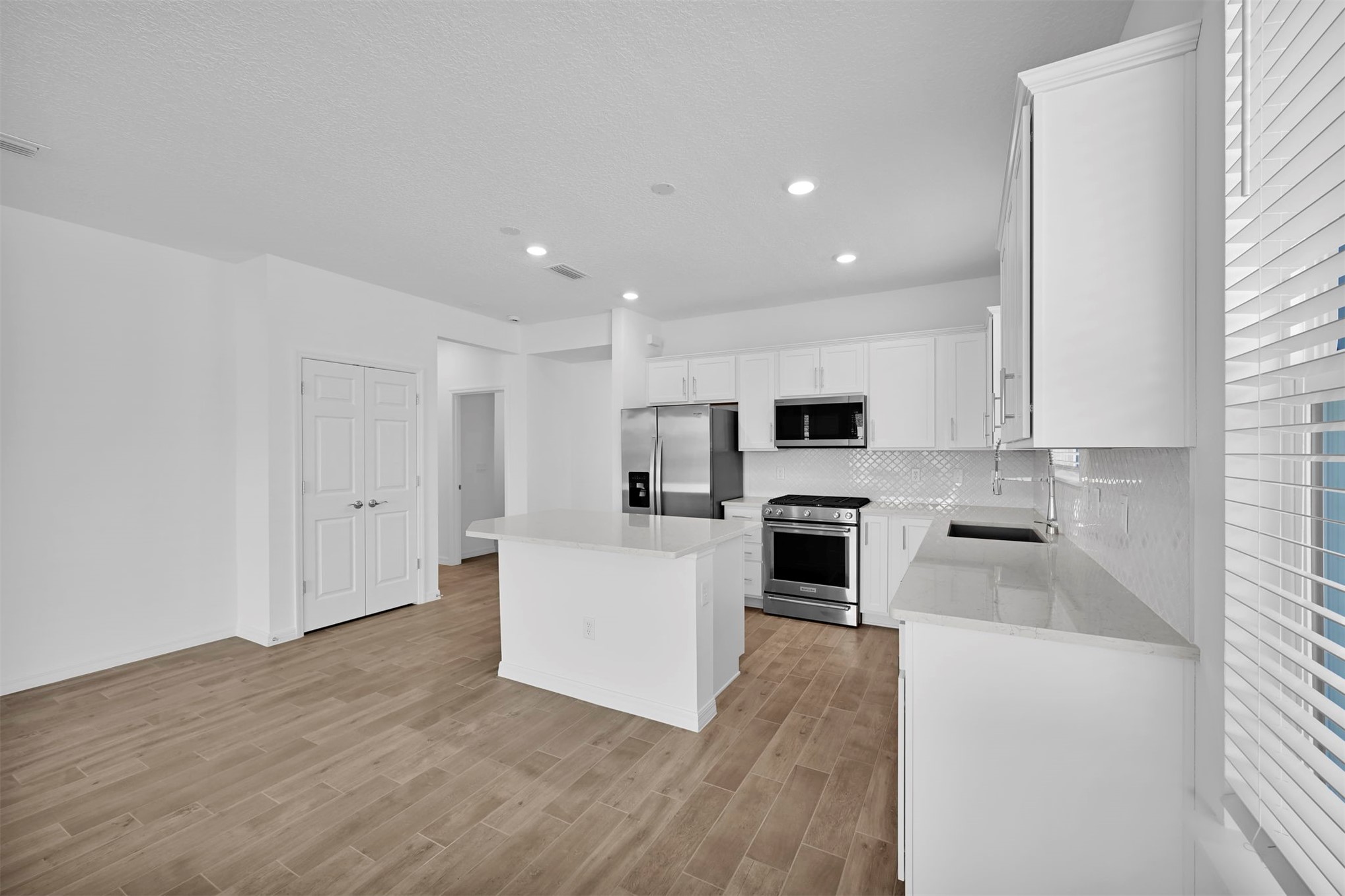 285 Ecliptic Loop Yulee, FL 32097 - Photo 7 of 42 a kitchen with white cabinets and stainless steel appliances