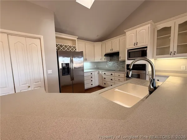 a kitchen with granite countertop a stove a sink and a refrigerator
