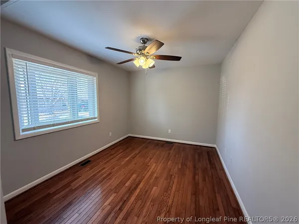 a view of empty room with wooden floor