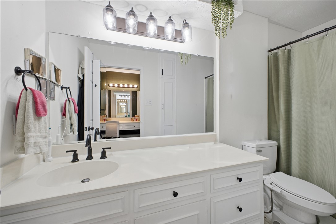 2012 Red River Drive Bryan, TX 77802 - Photo 17 of 23 a bathroom with a sink a toilet and a large mirror