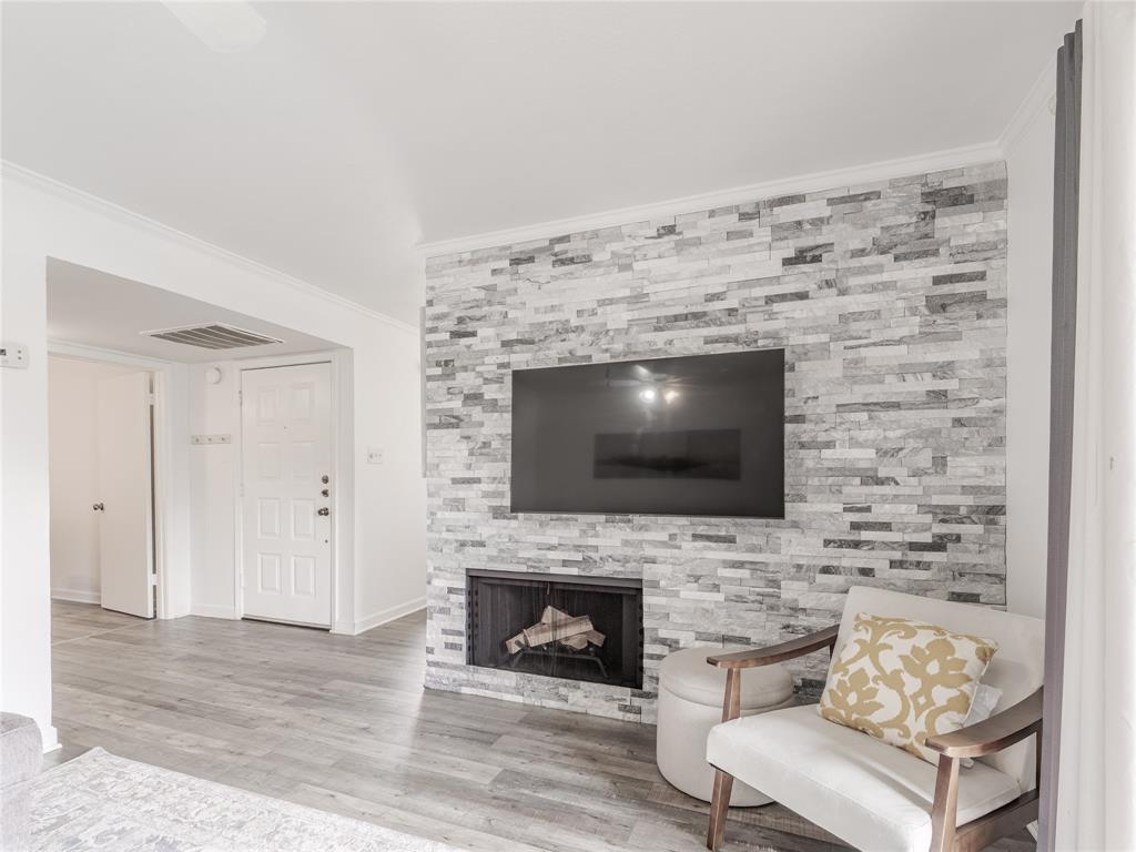 4748 Old Bent Tree Lane, Unit 201 Dallas, TX 75287 - Photo 1 of 17 Living area with crown molding, a fireplace, and wood finished floors