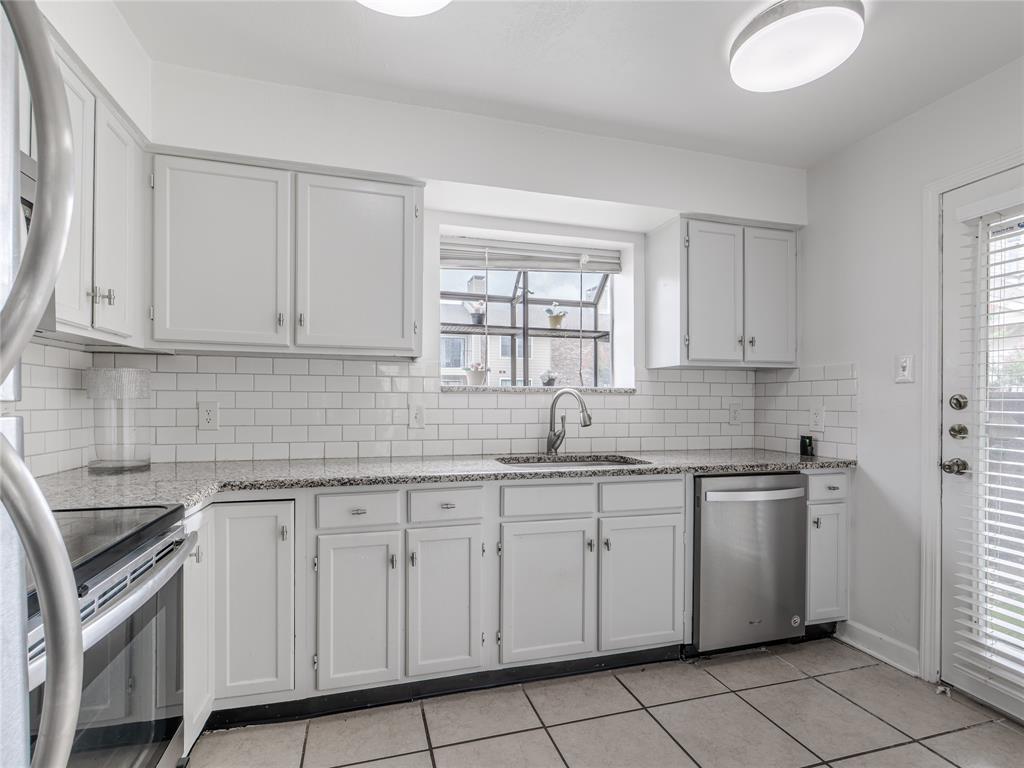 4748 Old Bent Tree Lane, Unit 201 Dallas, TX 75287 - Photo 11 of 17 Kitchen with healthy amount of natural light, stainless steel appliances, light stone countertops, and decorative backsplash